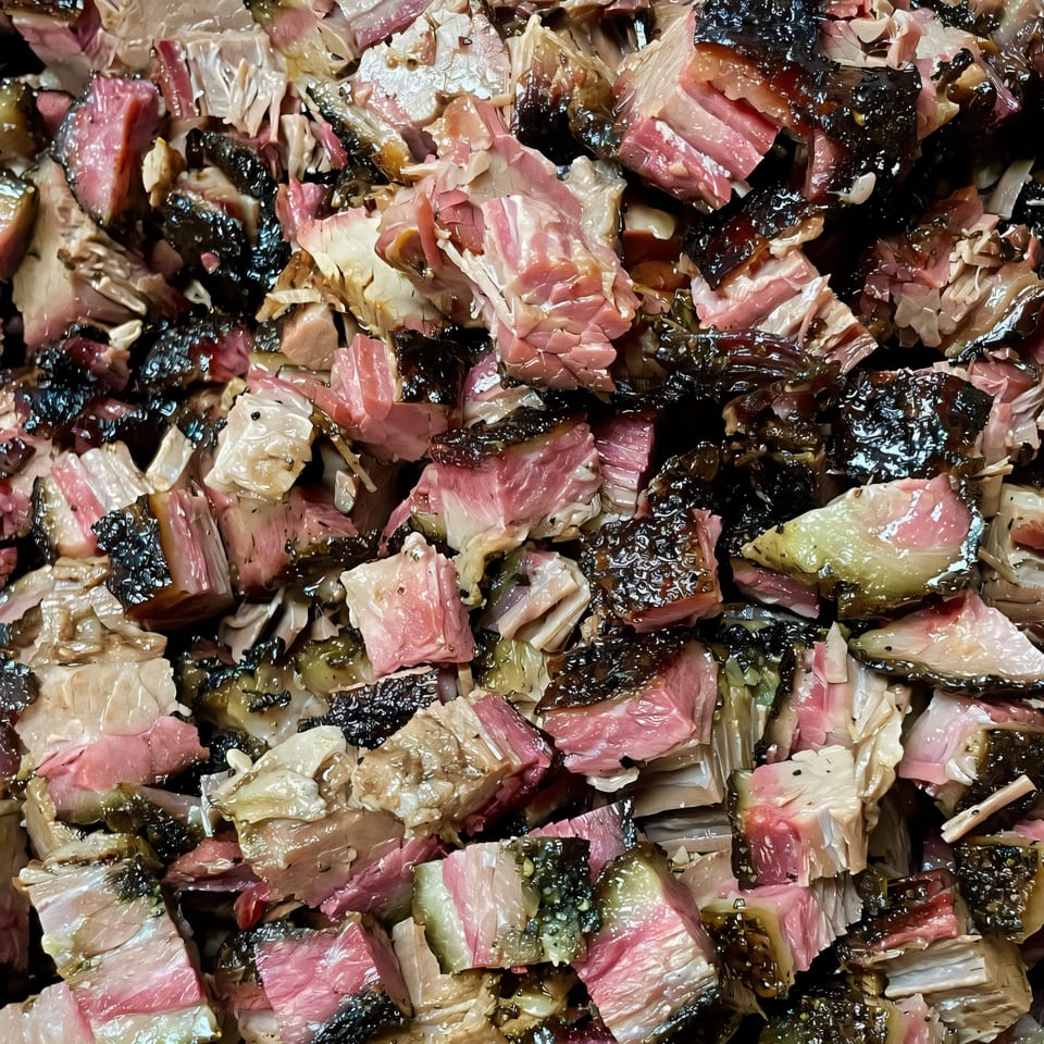 Close-up of diced teriyaki beef brisket with a dark, glistening crust and pink interior.